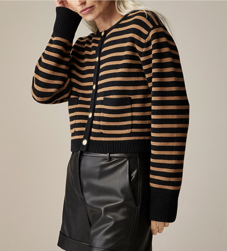 woman showing thanksgiving outfits- wearing a striped cardigan and leather pants